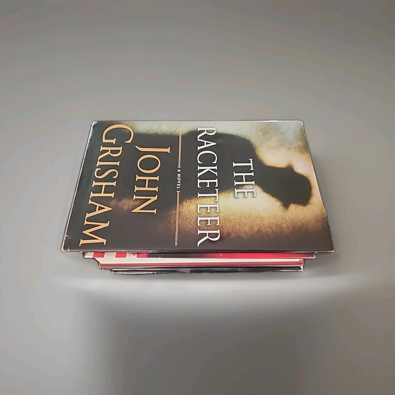 Lot of 3 Brad Taylor, Ken Follett and John Grisham hardcover books As Shown